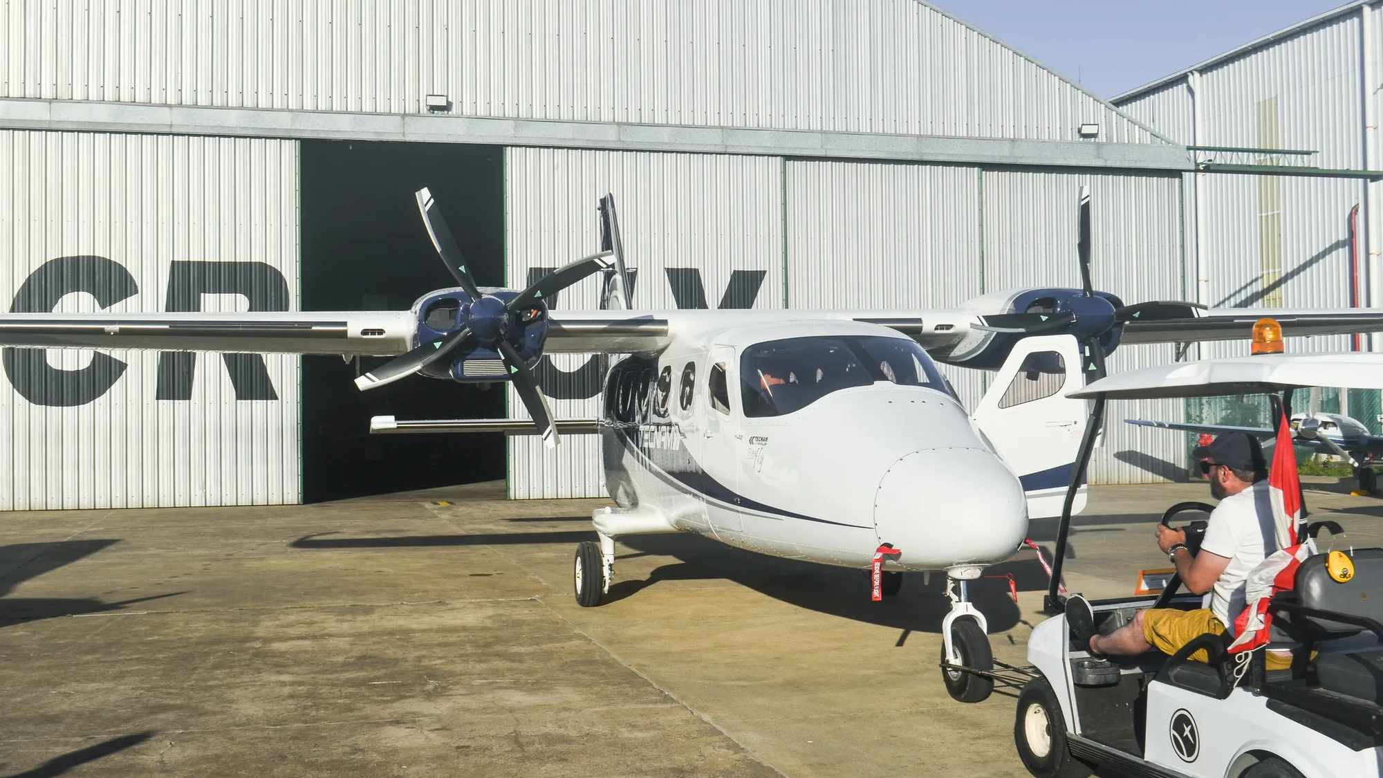 Twin-engine aircraft in front of the maintenance hangar